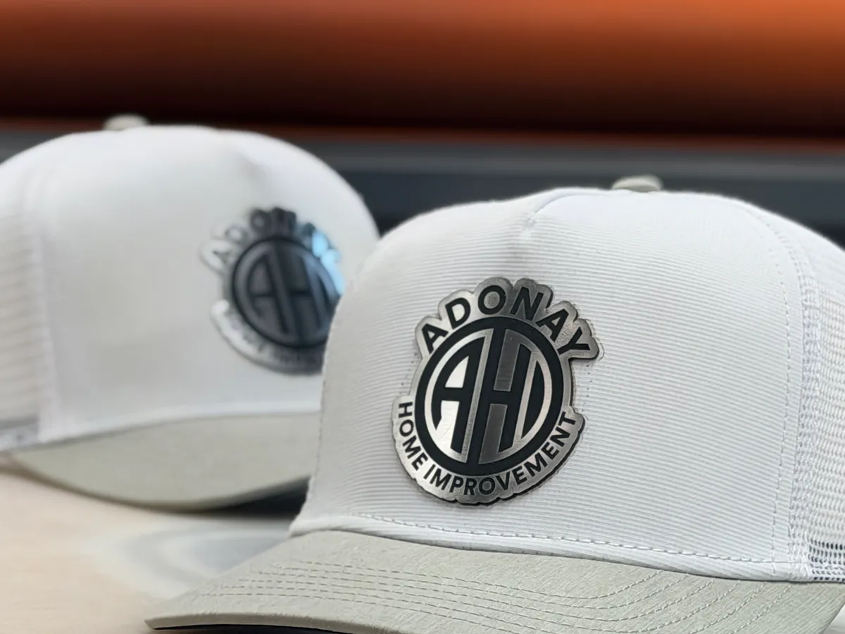 White trucker hats with laser engraved Adonay Home Improvement leather patches by Victory Laser Engraving Delaware