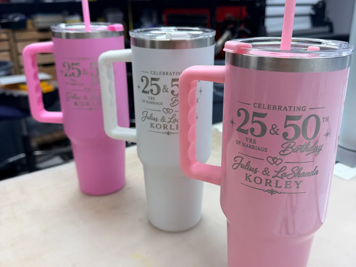 Pink and white 40oz handle tumblers laser engraved for a 25th anniversary and 50th birthday