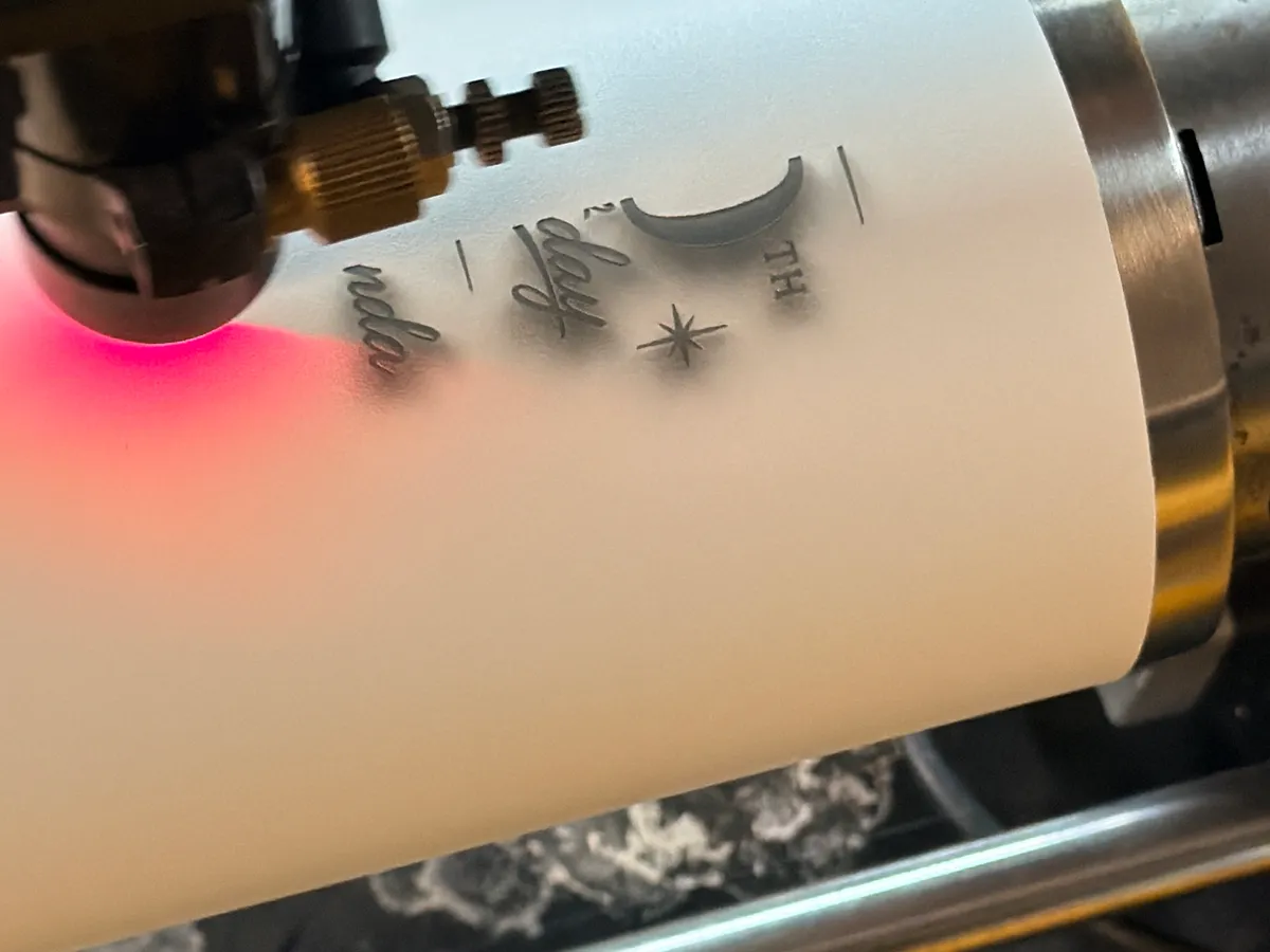 Fiber laser engraving a custom design onto a white tumbler at Victory Laser Engraving Wilmington Delaware